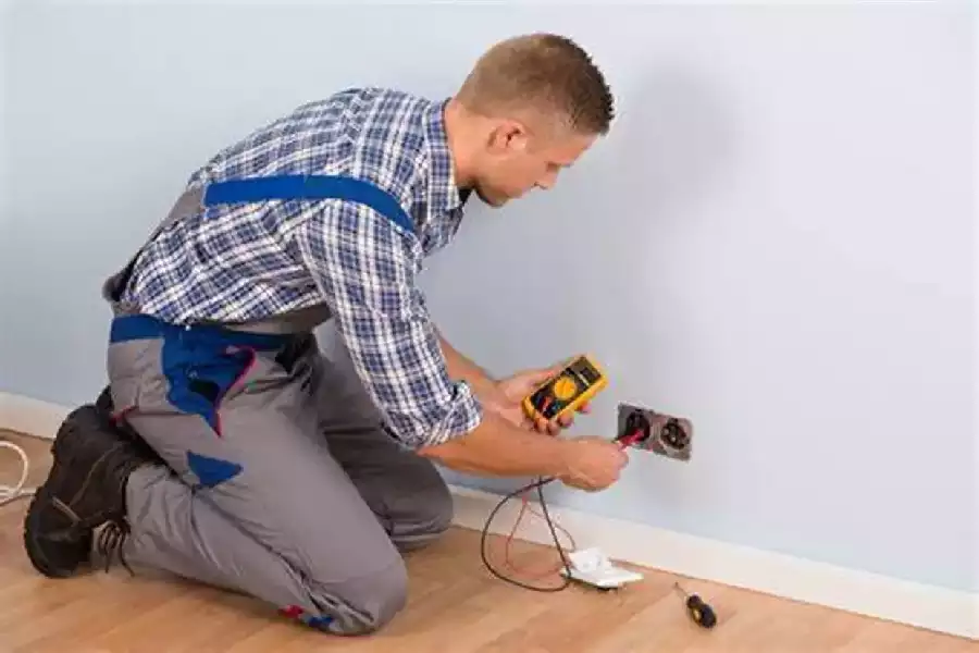 Image of a Certified Electrician testing a wall outlet